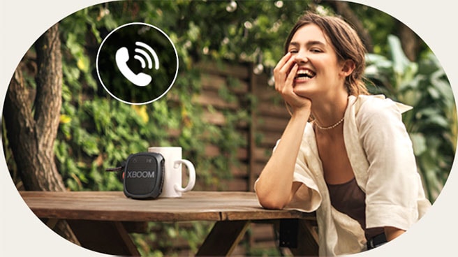 A woman is talking on the phone through LG XBOOM XG2 Speaker phone mode.